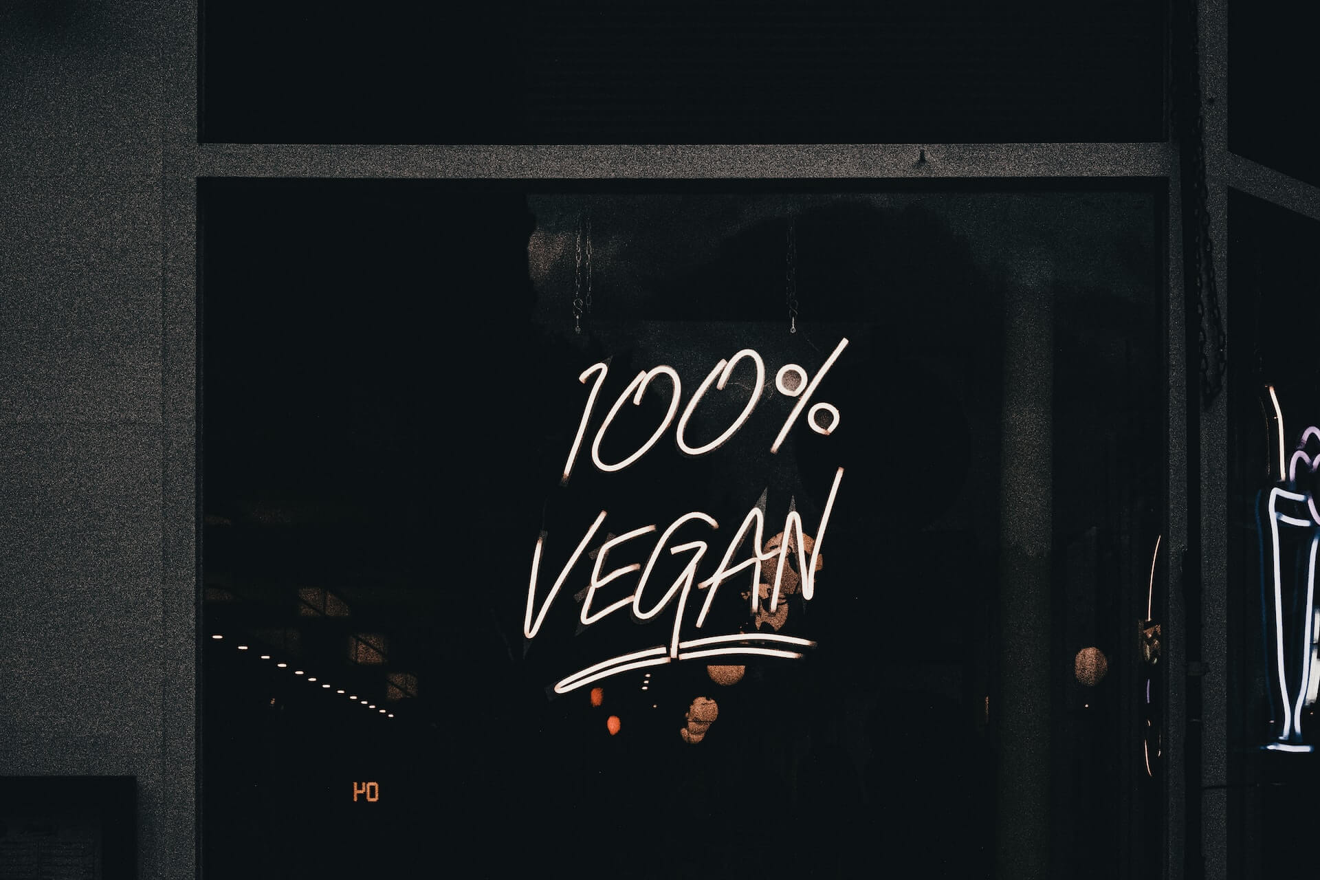 A neon sign reads "100% Vegan"