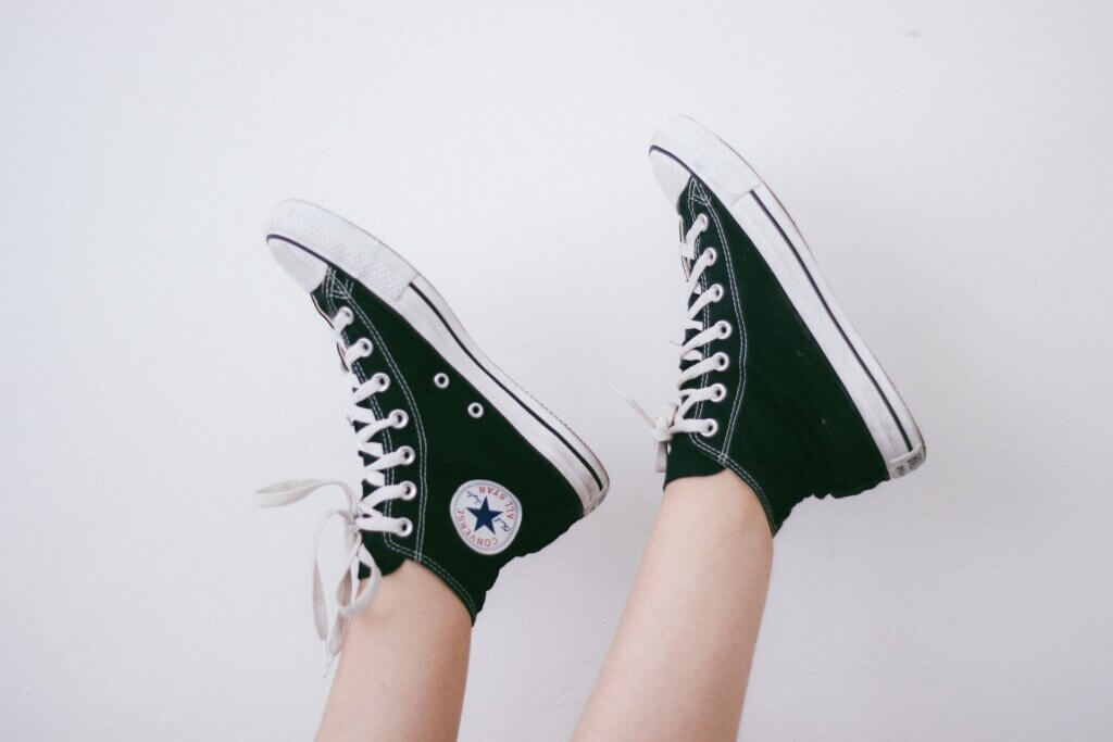 A model wears a pair of classic black and white Converse sneakers