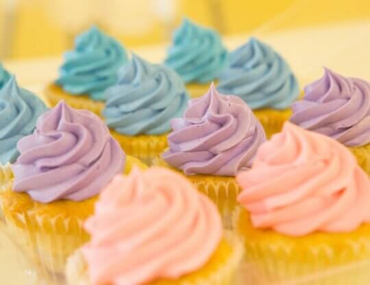 Colorful blue, purple, and pink iced cupcakes