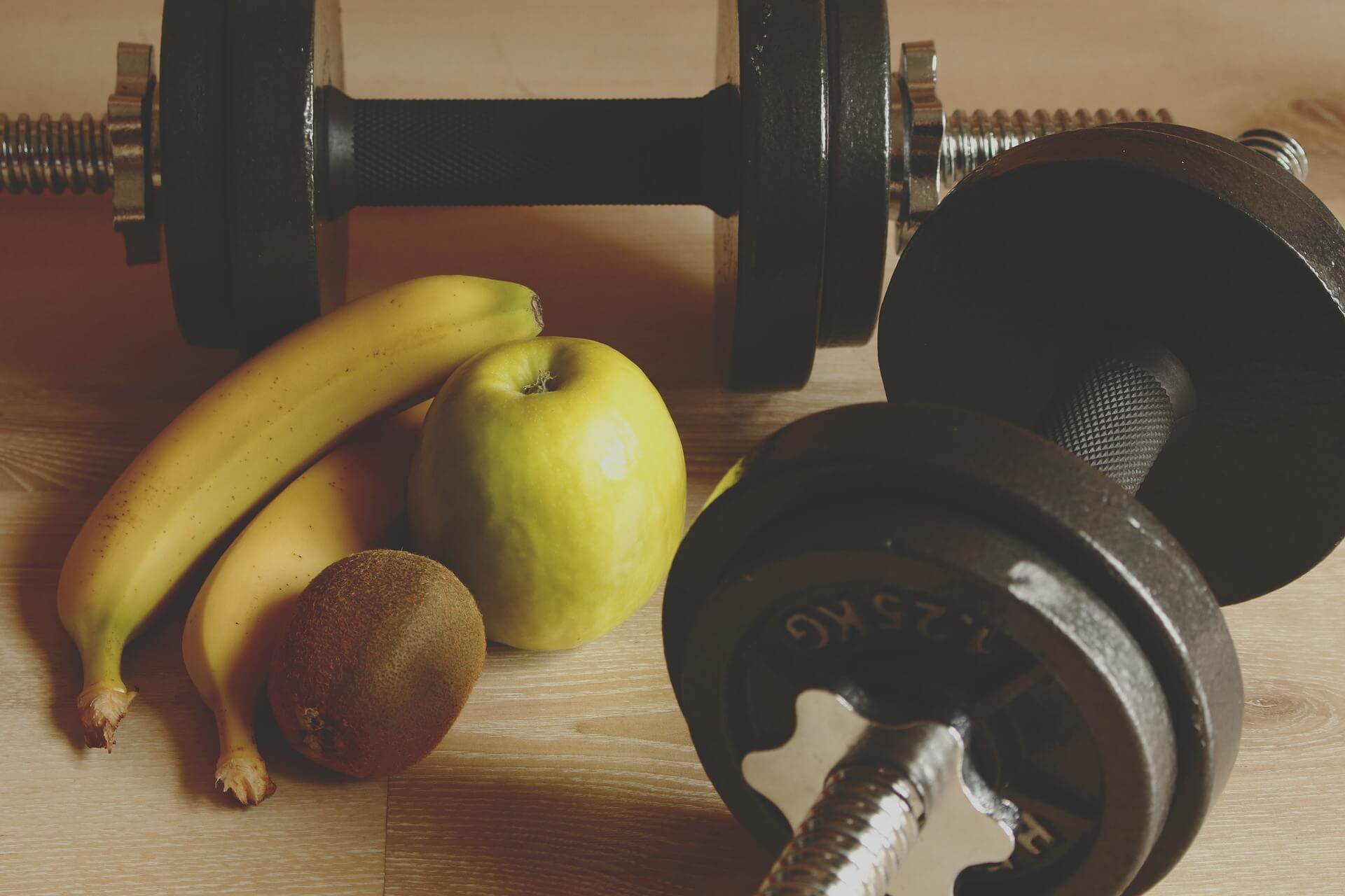 Weights on a table next to fruit