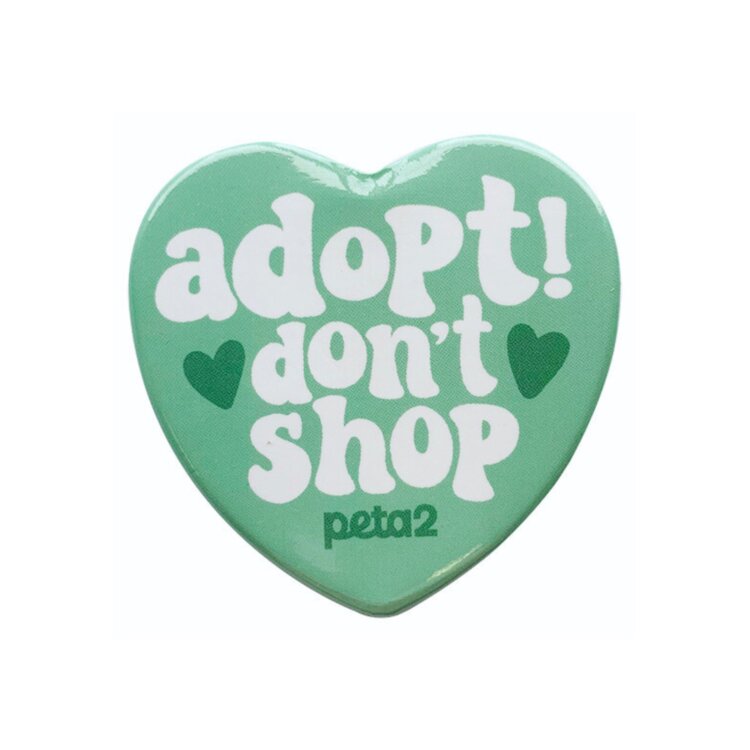 A teal heart-shaped enamel pin. It reads "Adopt! don't shop"