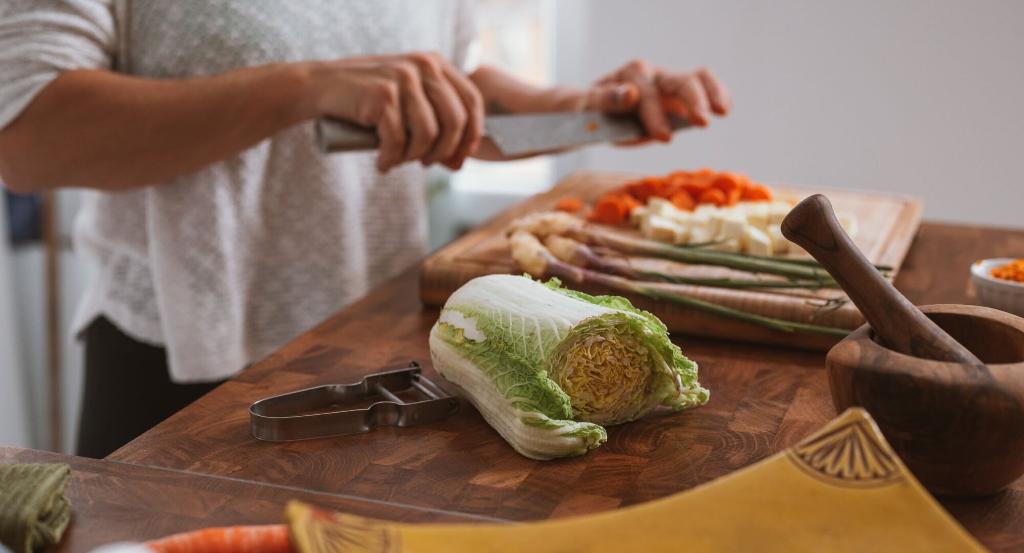 Image from Unsplash of someone cooking veggies for the cook at home feature
